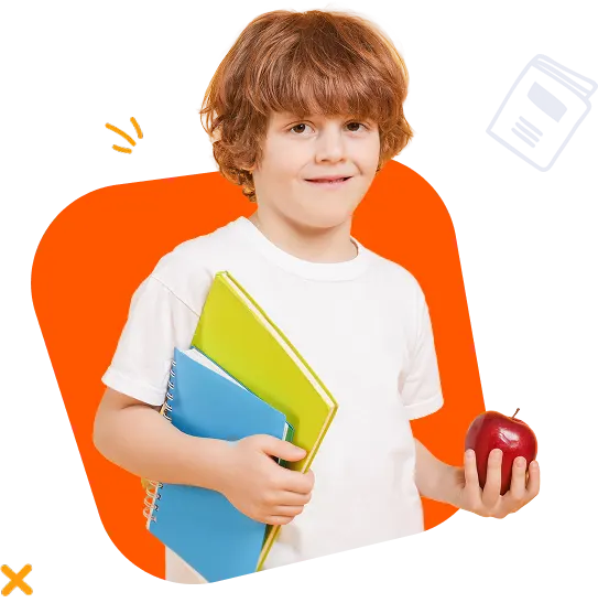 A smiling young boy holding a blue notebook, a yellow book, and a red apple.